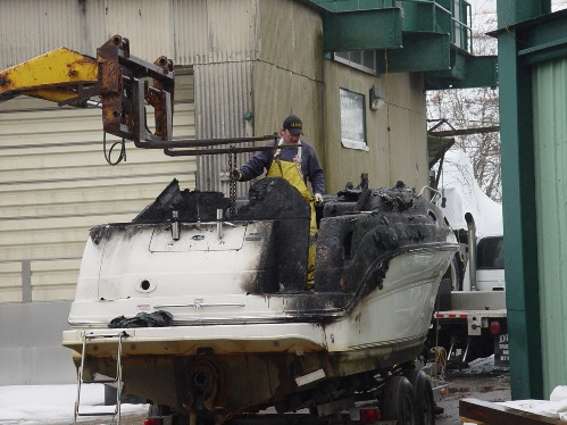 Man recycling a boat at a salvage yard