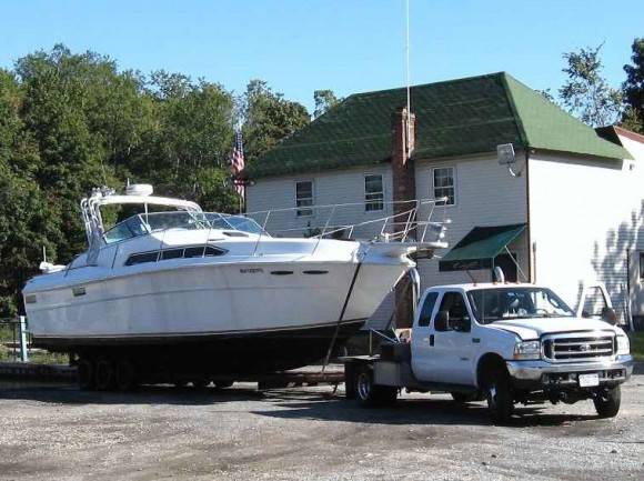 A boat and a trailer being moved by a truck